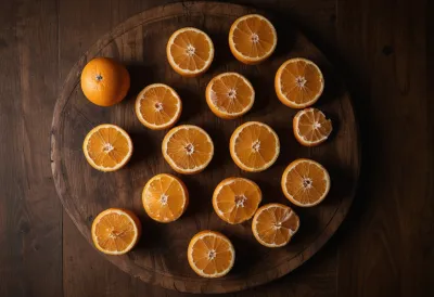 Halved oranges spread across a round wooden board